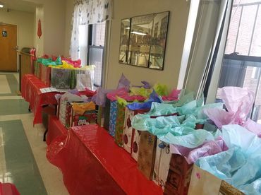 Long table with colorful gift bags lined up in a hallway.