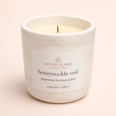 Elegant white candle labeled "honeysuckle veil" with Japanese honeysuckle scent.