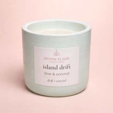 Elegant candle labeled 'island drift' with lime and coconut scent.