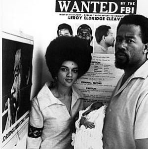 Kathleeen and Eldridge Cleaver in Algiers, Algeria in 1969 standing in front of a FBI Most Wanted Poster
