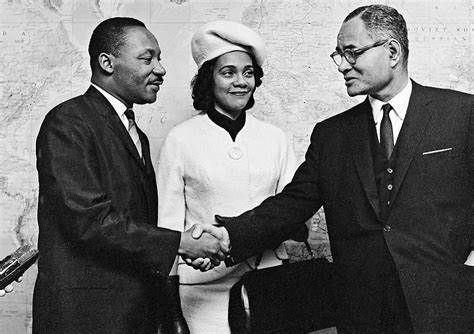 Ralph Bunche greeting Martin Luther King as Coretta Scott King looks on.