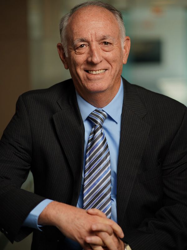 Smiling elderly man in a suit and striped tie.