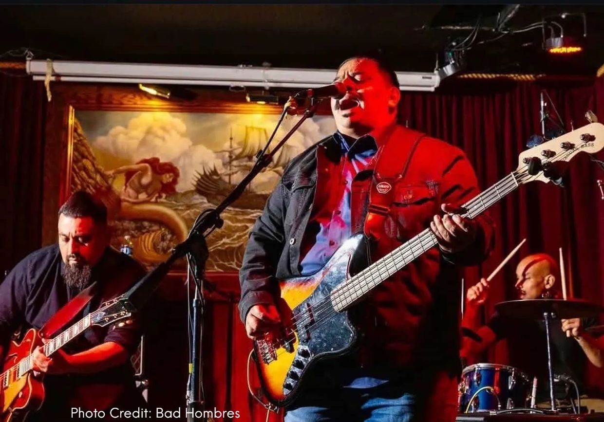 A band performs passionately on stage with vibrant lighting.