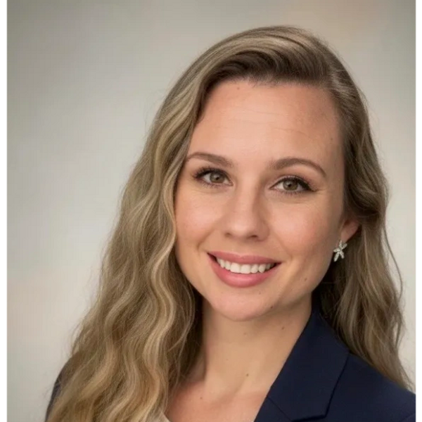 Professional woman with long wavy blonde hair smiling.