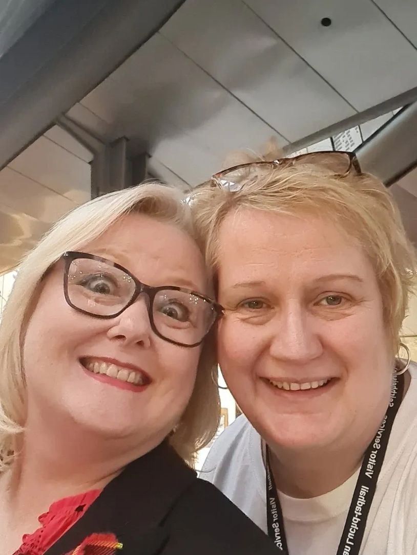 Myra Ross with Christina McKelvie MSP on the staircase at the Scottish Parliament d