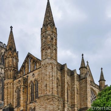 Gothic-style church with tall spires under a cloudy sky.