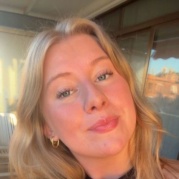 Young woman smiling in warm sunlight.
