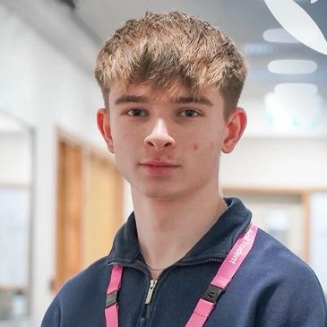 Young man with light brown hair and pink lanyard.