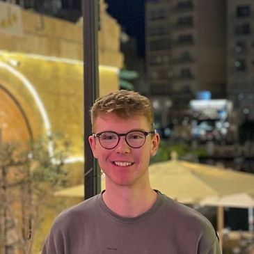 Young man smiling outdoors at night.