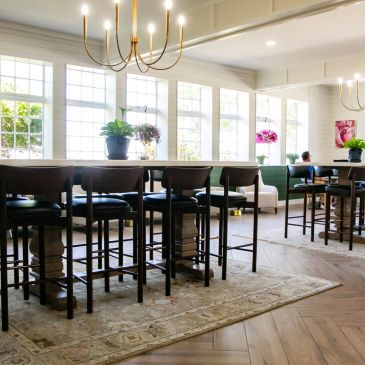 Bright dining area with wooden chairs and large windows letting in natural light.