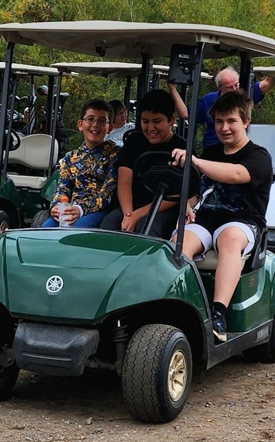 3 boys in a golf cart