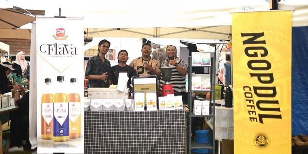 Four men at a coffee stall with Flava and Ngoppul Coffee banners.