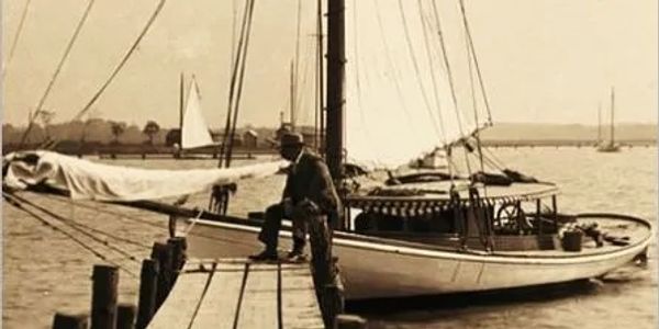 Old world sailboat at Bellport village dock, in sepia tone, evoking a feeling of history & community