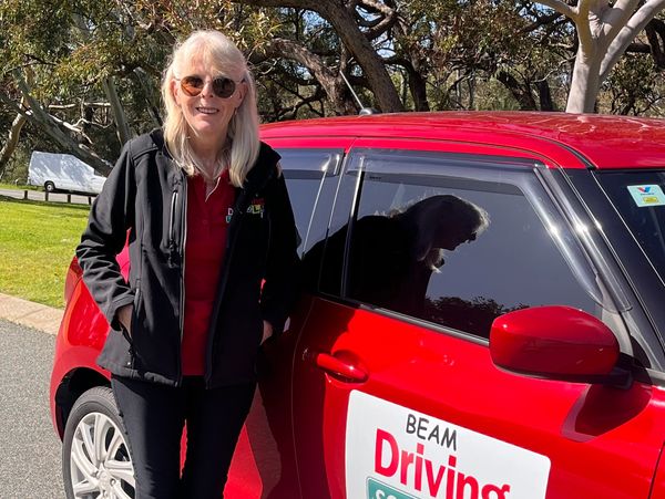 Female driving instructor standing next to car in North Lake,south lake ,leeming,