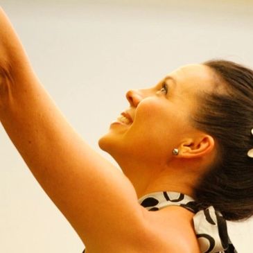 Hula dancer lifting her hands in the air to tell the story of hula. 