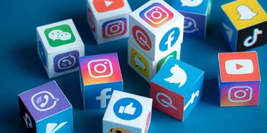 Colorful cubes featuring popular social media logos on a blue surface.