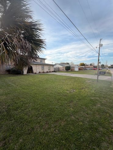 Residential neighborhood with green lawns and clear sky.
