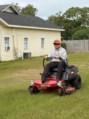Person mowing lawn with a Toro Timecutter mower.
