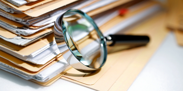 Loupe avec des documents. Mission du Groupe BIRA