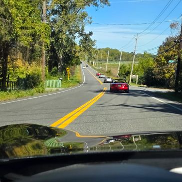 A scenic road with cars driving under a clear blue sky.
