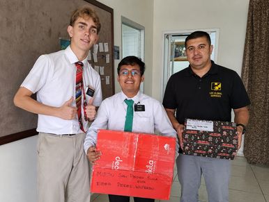Three men holding gift boxes indoors.
