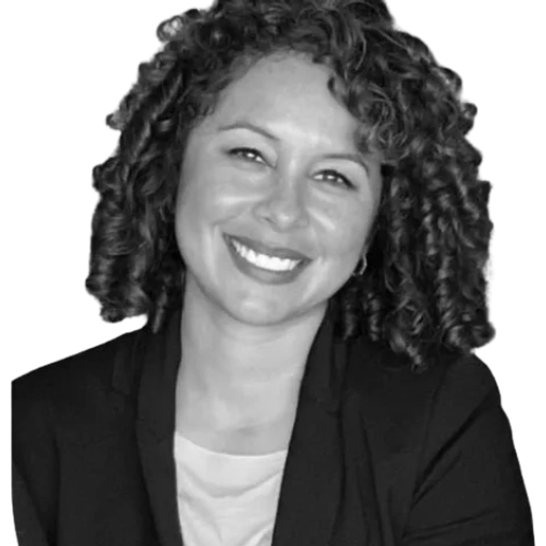 Smiling woman with curly hair wearing a blazer.
