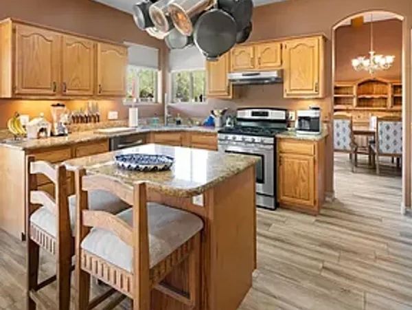 Cozy kitchen with wooden cabinets and marble island.