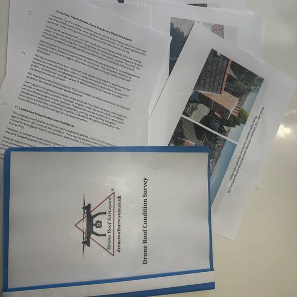 Printed drone roof condition survey report with images and detailed text.