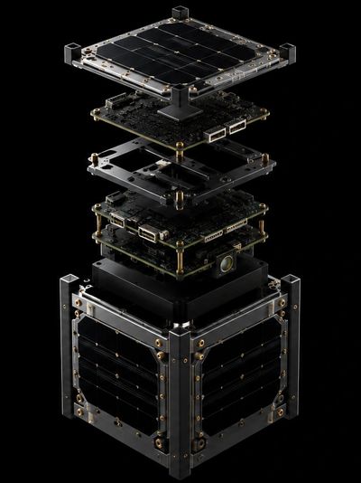 Exploded view of a small satellite with solar panels and circuit boards.