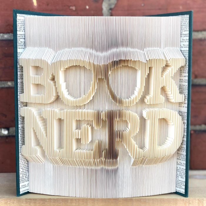 Book Nerd book art piece folded into a Green covered book with book pages added on inside cover.