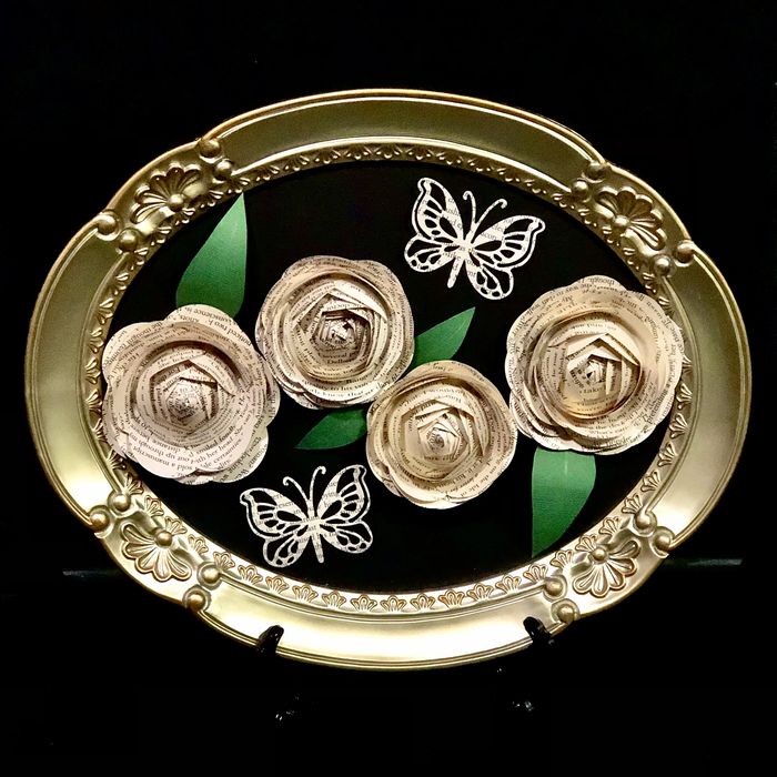 Gold tone oval frame with 4 book page flowers & 2 butterflies displayed against a black background.