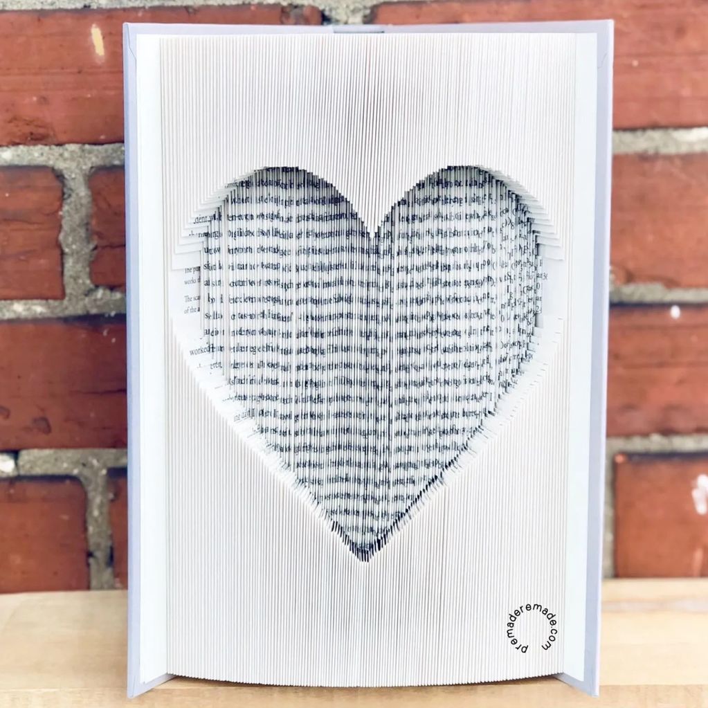 a book with the pages folded to form a heart in the middle