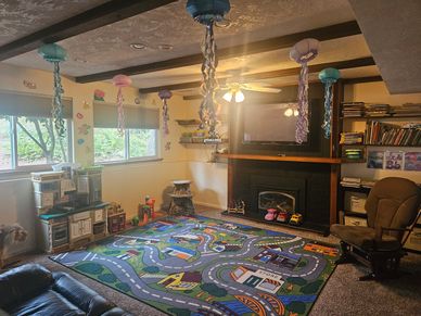 Cozy playroom with colorful jellyfish decor and a road-themed rug.