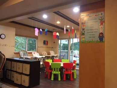 Colorful children's play area with small chairs and hanging decorations.