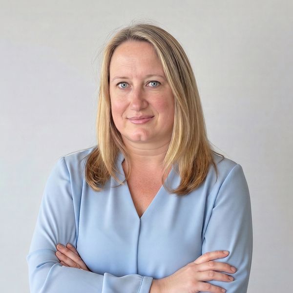 Confident woman with blonde hair in a light blue blouse.