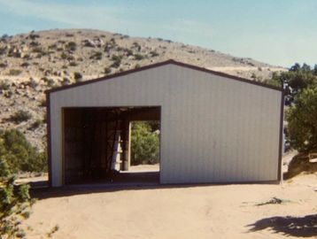 A partially constructed metal building in a desert-like area.