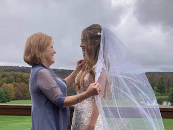 Bride in wedding gown with veil having a beautiful grandmother moment