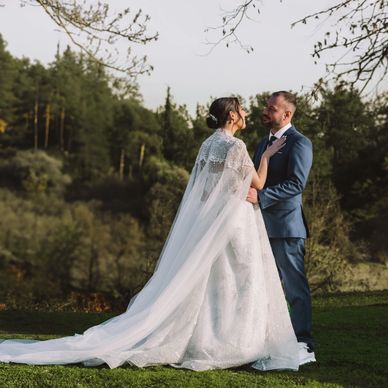 Bride and groom sharing a tender moment outdoors on their wedding day.