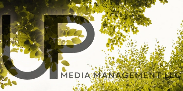 UP Media Management LLC logo on sky view through the trees