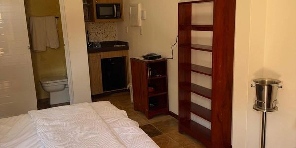 Cozy room with bed, kitchenette, and bathroom.