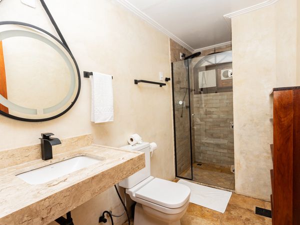 Modern bathroom with stone countertop and glass shower enclosure.