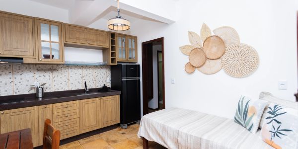 Cozy kitchen and sitting area with wooden cabinets and decorative wall art.