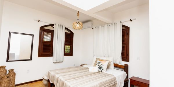 Cozy bedroom with wooden windows and neutral decor.