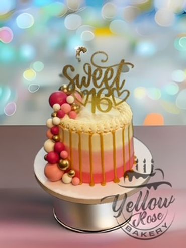 Elegant pink and gold Sweet 16 cake with decorative balls and drip icing.