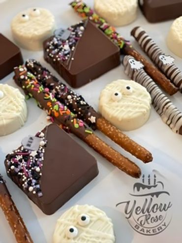 Assorted Halloween-themed chocolate treats and decorated pretzels.
