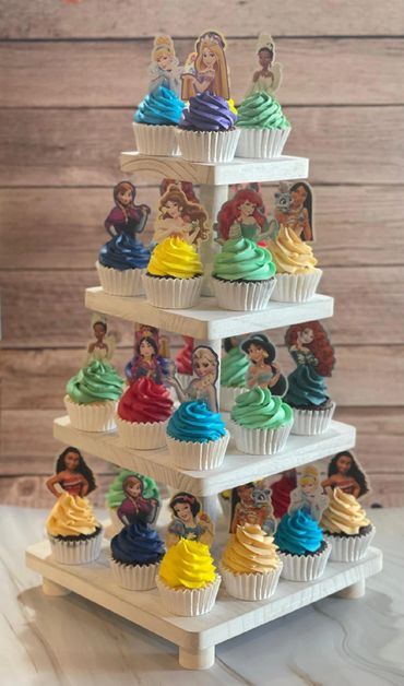 Colorful princess-themed cupcakes on a tiered stand.