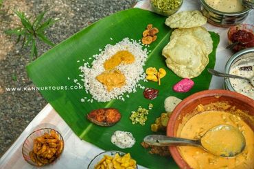 Group travelers from Europe savor Kannur's cuisine, enjoying local specialties.Kerala Tourism.