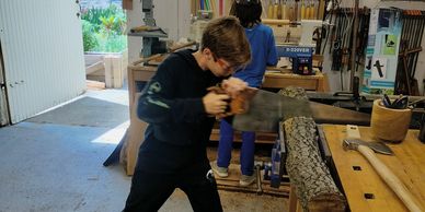 Two boys woodworking in a well-equipped workshop.