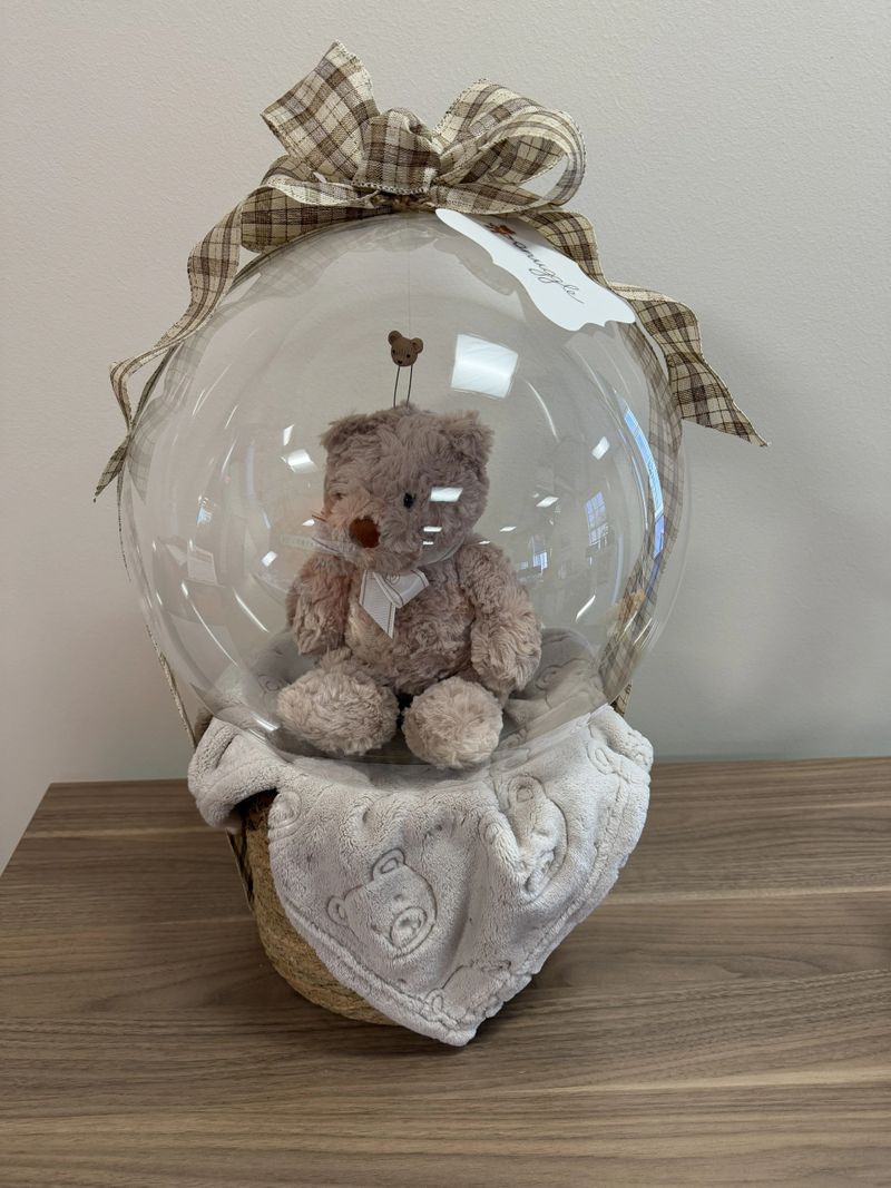 Balloon Gift with a soft toy bear in a clear ballon with basket base and bow.