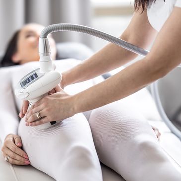 A woman receiving a body contouring treatment on her thighs for cellulite reduction. 